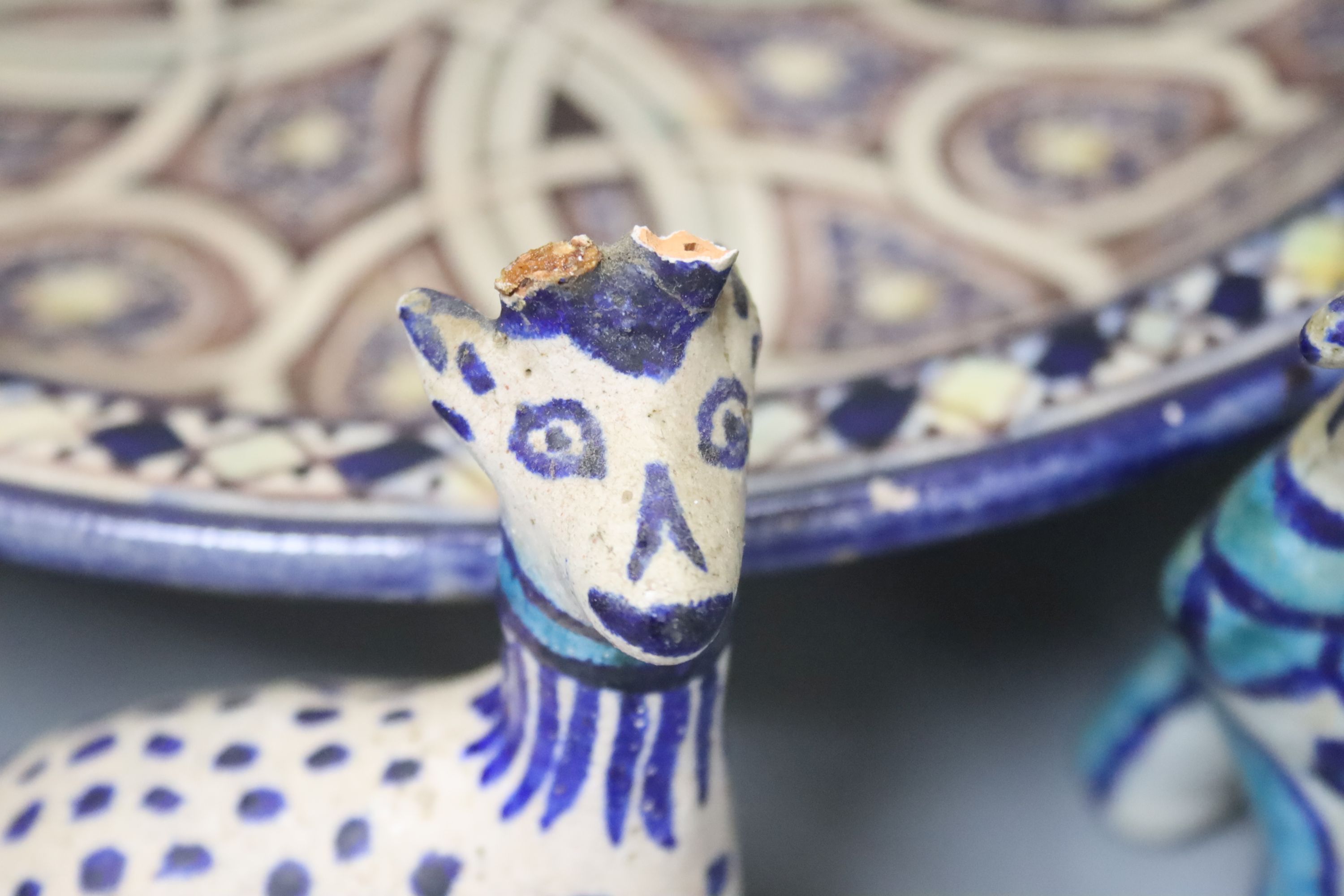 A Moroccan pottery dish, diameter 36cm, and three fritware animal figures